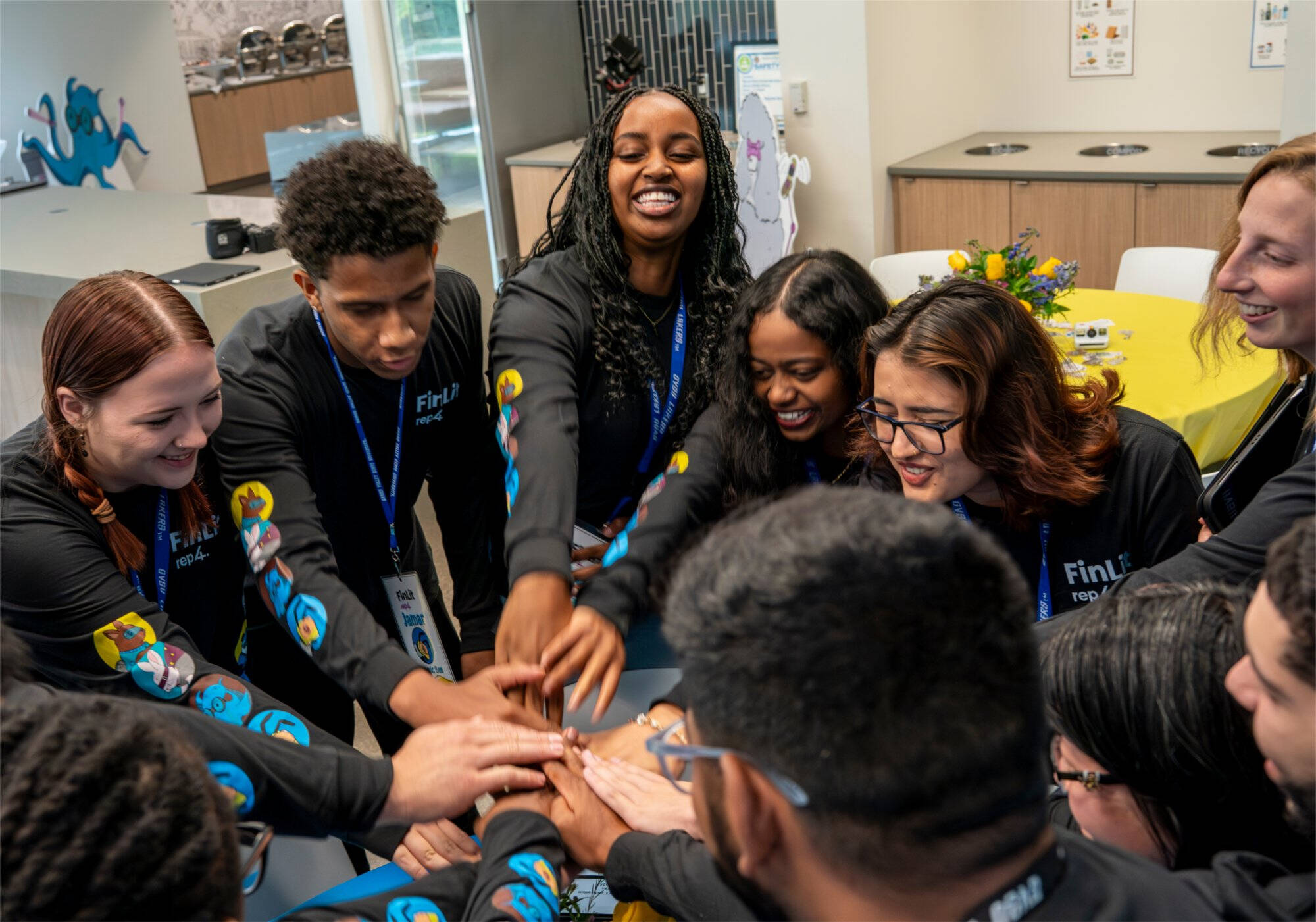 Students in a huddle with hands in